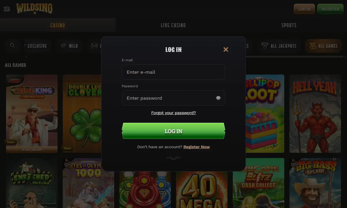 Dunkles Log-in-Fenster von Wildsino Casino über der Spielelobby, beide Eingabefelder leer, darunter ein grüner Knopf und der Link Forgot your password